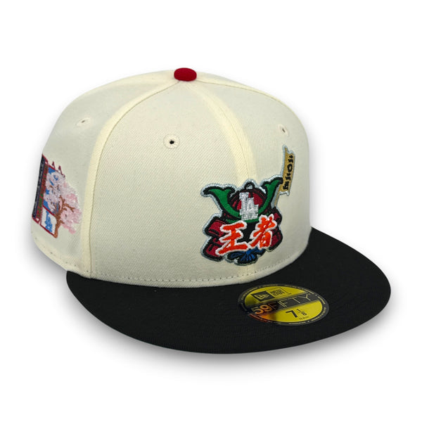A structured baseball cap with an off-white crown, black flat brim, red button on top, and colorful embroidered patches on the front and side. A yellow New Era 59FIFTY sticker is visible on the brim.