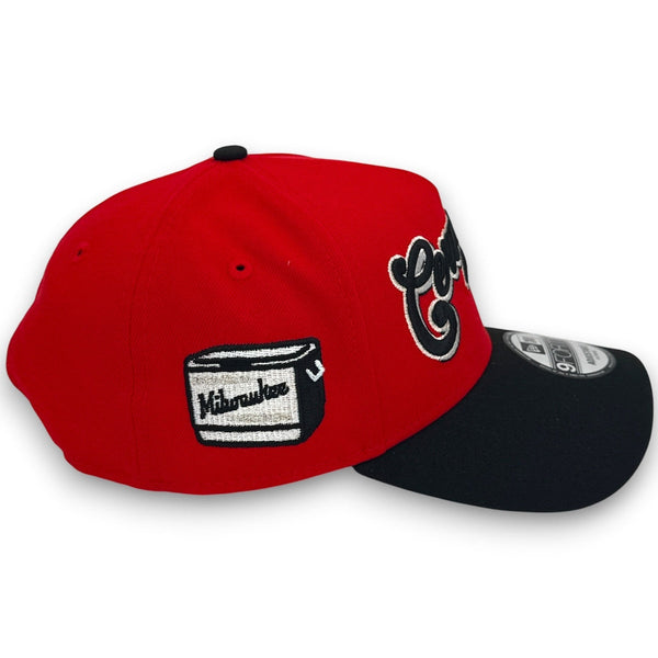 Red and black cap with Milwaukee logo on a white background