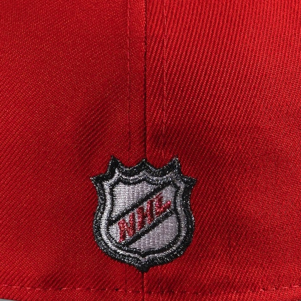 Close-up of a red cap with a NHL logo on a red background