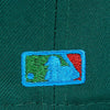 Close-up of a green cap with a embroidered logo on a green background