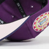 Close-up of a purple cap with a colorful patch on a white background