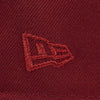 Close-up of a embroidered logo on a maroon fabric background