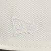 Close-up of a textured fabriThe Pirates Expos 02 ASG 59FIFTY Brick New Era Hat c surface with a logo or emblem.
