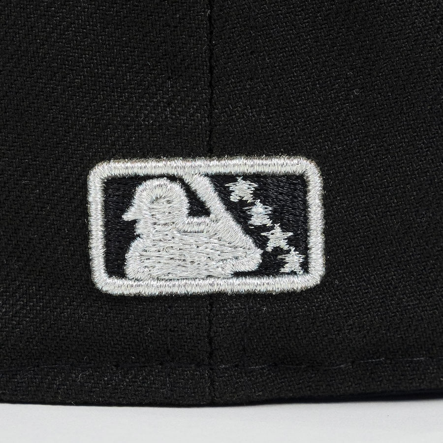 Embroidered logo on a black cap with a white silhouette of a person and stars. Bradenton Marauders
