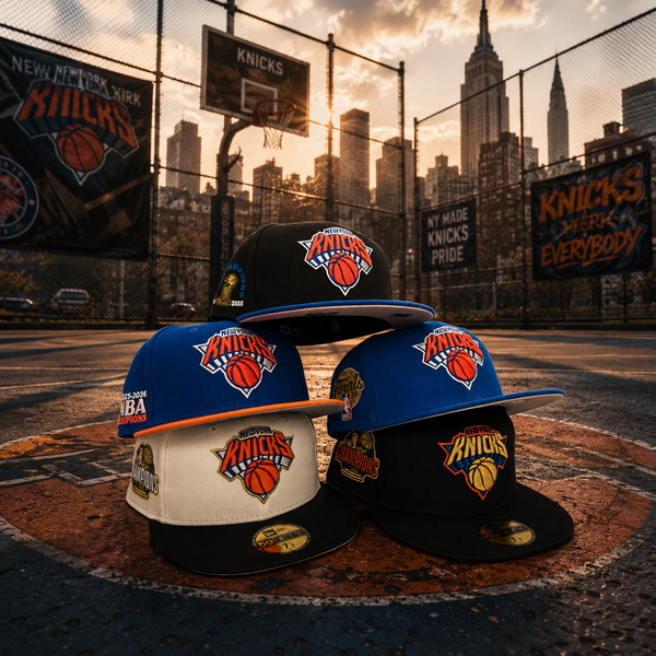Four New York Knicks fitted caps in different colorways (blue, cream, and black) arranged on a basketball court with a city skyline and chain-link fence in the background.